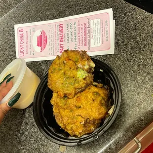 a person holding a cup of coffee and a plate of fried food