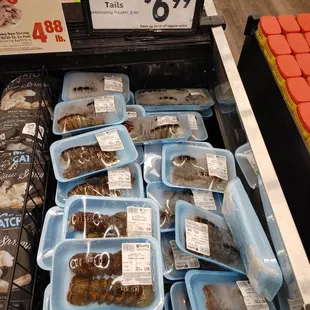 a display of frozen fish in plastic containers