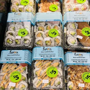 a variety of sushi in plastic containers