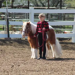A young student working with her pony.