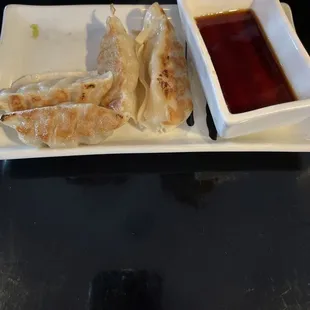 a plate of dumplings and dipping sauce