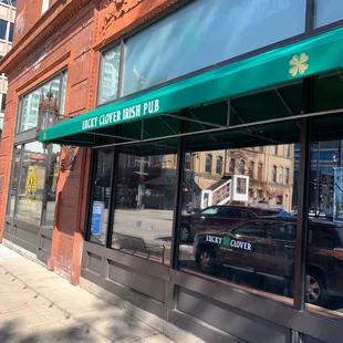 the front of a restaurant with a green awning