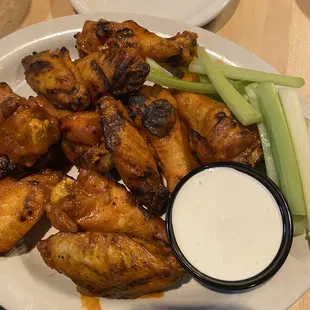 a plate of chicken wings with a side of ranch dressing