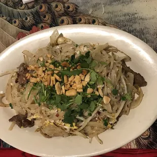 a plate of noodles with meat and vegetables