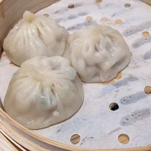 three dumplings in a bamboo basket