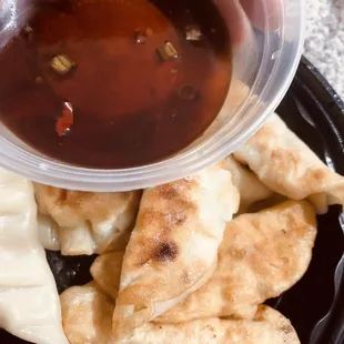 a plate of dumplings and dipping sauce