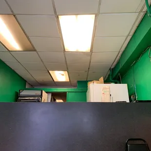 a kitchen with green walls and a black refrigerator