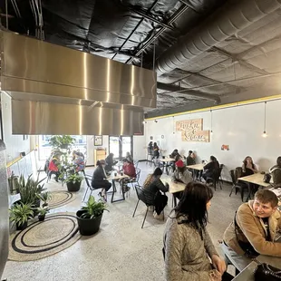 a group of people sitting at tables in a restaurant