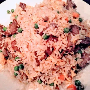 a plate of rice with meat and peas