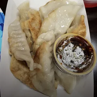 a plate of dumplings with dipping sauce