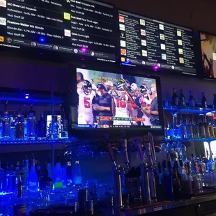 a large television and a lot of liquor bottles