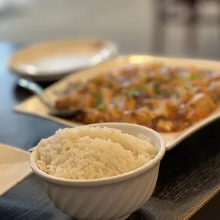 a bowl of rice and a plate of chicken