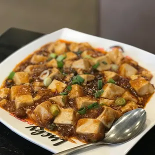 a plate of tofu with a spoon
