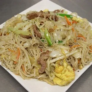a plate of noodles with meat and vegetables