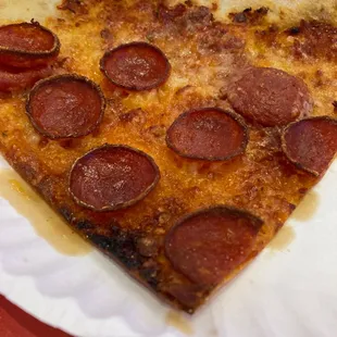 a slice of pepperoni pizza on a paper plate