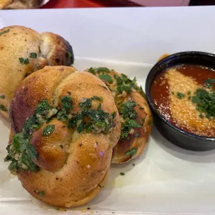 a plate of bread rolls and a bowl of sauce