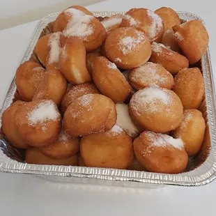 a tray of powdered donuts