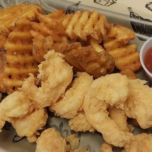 a plate of fried shrimp and waffle fries