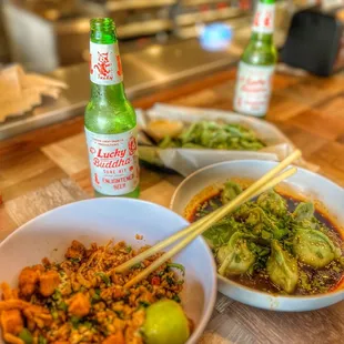 two bowls of food and a bottle of beer