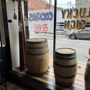 two wooden barrels in front of a window