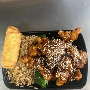 a plate of chinese food with rice and broccoli