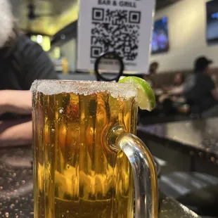 a glass of beer with a lime wedge