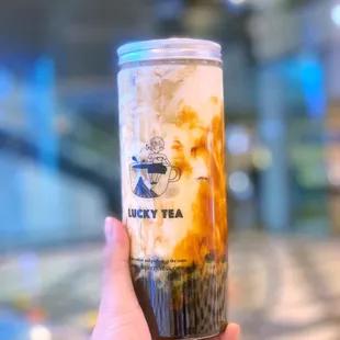 a hand holding a cup of iced coffee