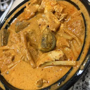 chicken curry in a black bowl