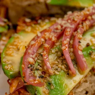 Avocado toast on foccacia with pickled onion, hemp hearts, and chile-infused EVOO