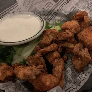 a basket of fried chicken wings with a side of ranch dip