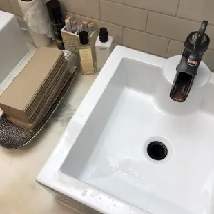 Products in the womens bathroom - hairspray, tampons, perfume, and lotion