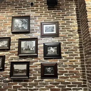a brick wall with old photos on it