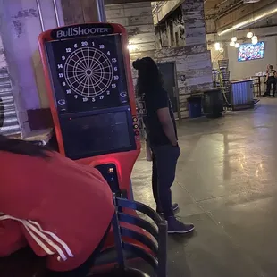 a man standing in front of a dart board