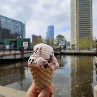a hand holding a cone of ice cream