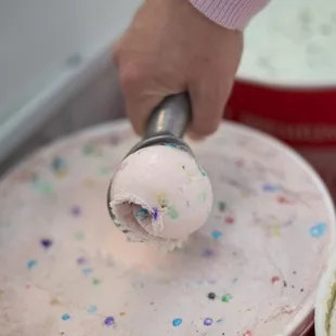 a person scooping a scoop of ice cream