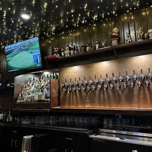 a bar with beer taps and a television