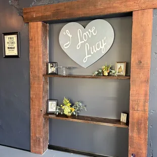 a wooden shelf with a heart shaped sign on it