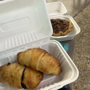 Croissant and chocolate croissant in a recyclable container. And in the back a very delicious pecan pie!