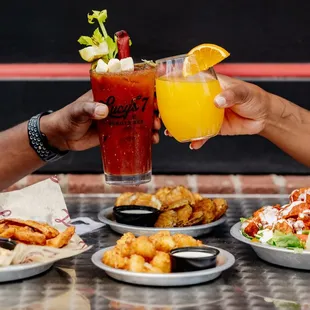  two people toasting with drinks