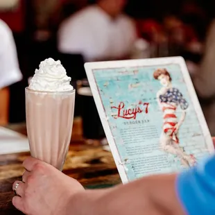  a woman holding a milkshake