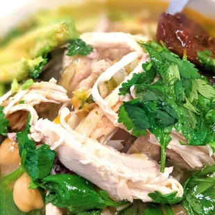 a bowl of soup with chicken and greens