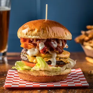 a burger with bacon, cheese, lettuce, and a side of fries