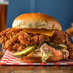 a fried chicken sandwich with pickles and cheese