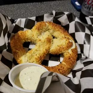 a pretzel and a bowl of dip