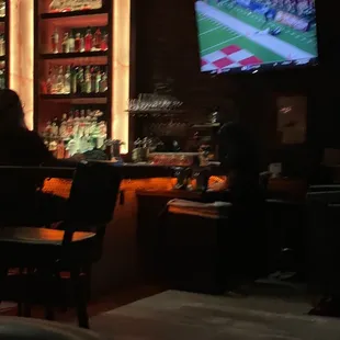 people sitting at a bar watching a football game