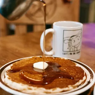 a plate of pancakes with butter and syrup
