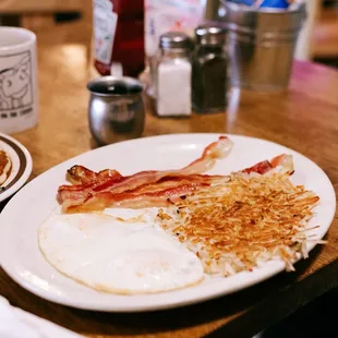 a breakfast of eggs, bacon and hash browns