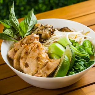 a bowl of noodles with chicken and vegetables