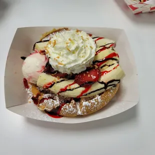 a waffle topped with whipped cream, strawberries, bananas, and chocolate