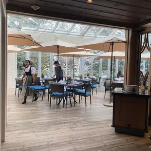 a dining room with tables and umbrellas